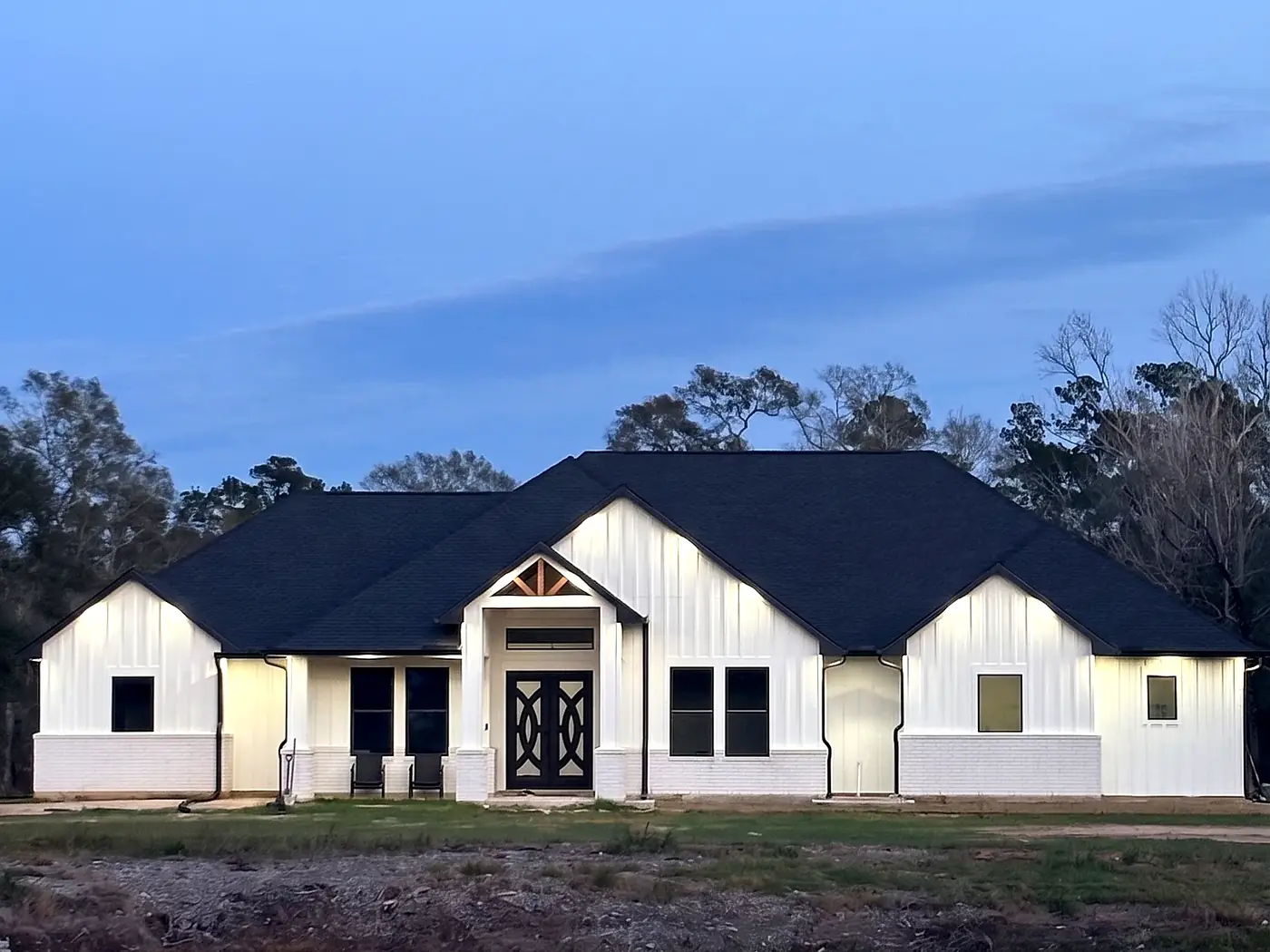 Completed custom home at dusk with its lights on