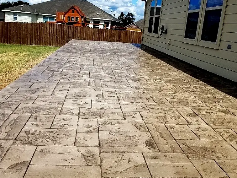 Stamped concrete patio in an ashlar slate pattern behind a home