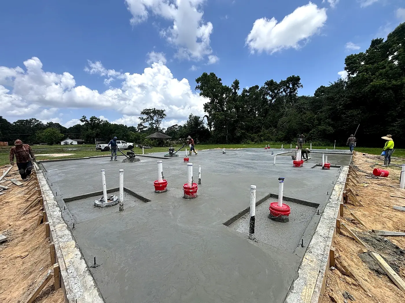 Crew finishing a freshly poured concrete slab with power trowels